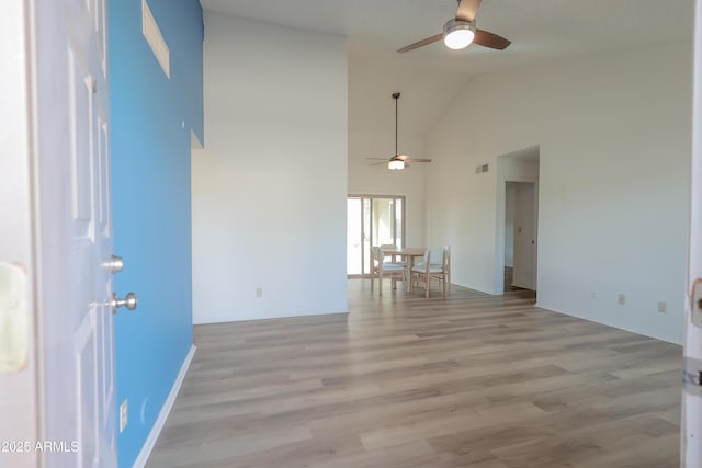 unfurnished room with ceiling fan, high vaulted ceiling, and light hardwood / wood-style floors