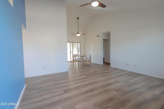 unfurnished living room with high vaulted ceiling, light hardwood / wood-style floors, and ceiling fan