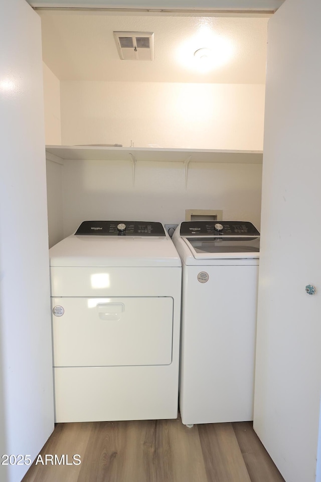 laundry room with hardwood / wood-style floors and independent washer and dryer