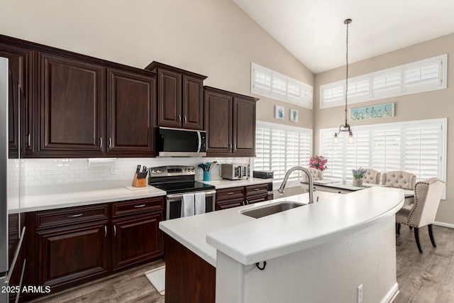 4137 E Stanford Ave, Gilbert, AZ 85234 - kitchen with stainless steel electric range oven, light wood-type flooring, high vaulted ceiling, tasteful backsplash, and light countertops