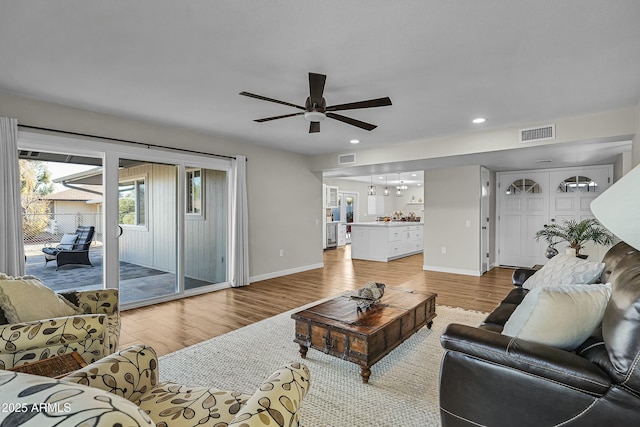 living room with light hardwood / wood-style floors and ceiling fan