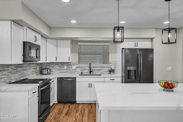 kitchen featuring white cabinets, sink, decorative light fixtures, and black appliances