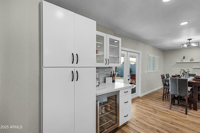 kitchen featuring white cabinetry, beverage cooler, and light wood-type flooring