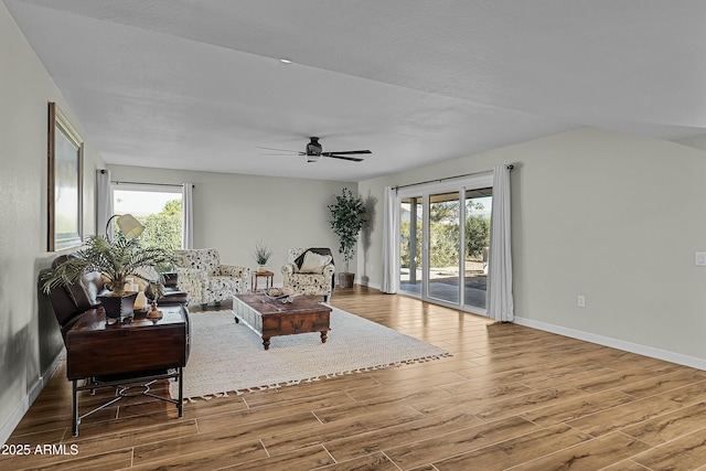 living room featuring ceiling fan and a healthy amount of sunlight