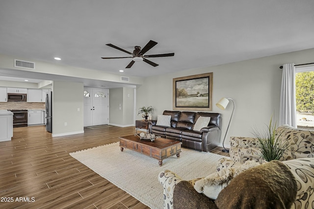 living room with ceiling fan and dark hardwood / wood-style flooring