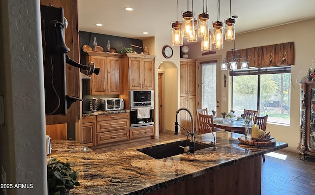 4990 N Pine Creek Canyon Dr, Pine, AZ 85544 - kitchen featuring arched walkways, recessed lighting, wood finished floors, dark stone countertops, and hanging light fixtures
