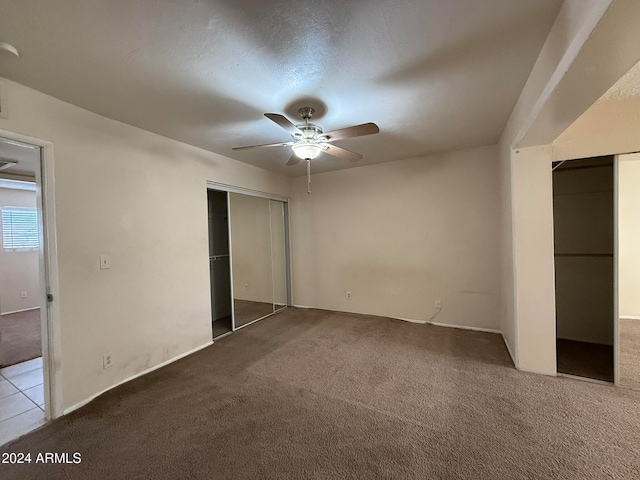 unfurnished bedroom featuring ceiling fan, light carpet, and a textured ceiling