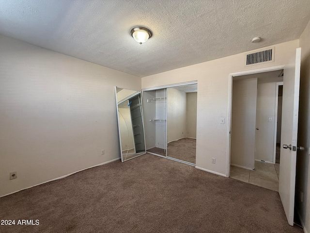 unfurnished bedroom featuring carpet flooring, a closet, and a textured ceiling