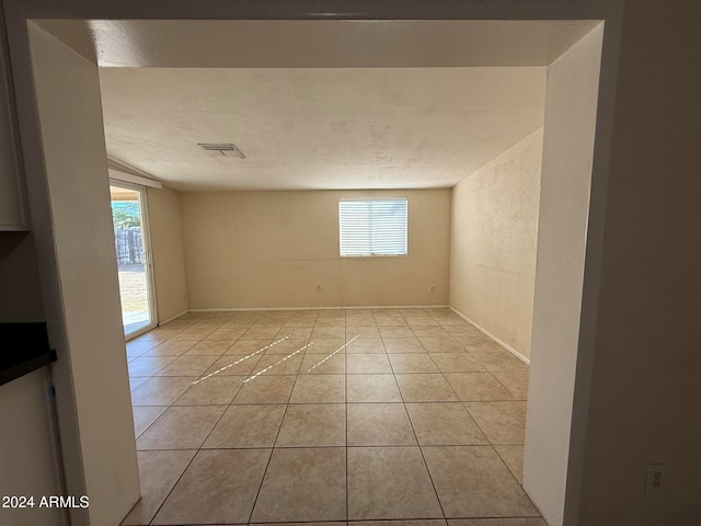 unfurnished room with light tile patterned floors and a textured ceiling