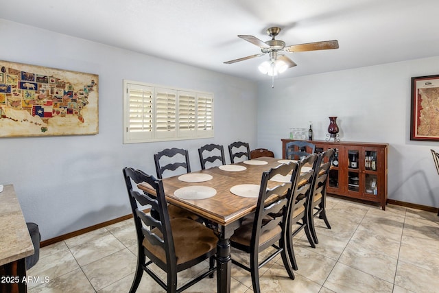 dining area featuring light tile patterned floors, ceiling fan, and baseboards