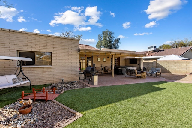 rear view of house with a patio, fence, a yard, cooling unit, and brick siding