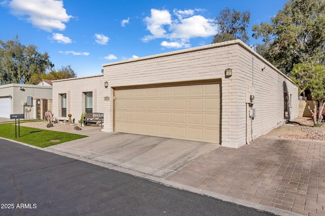 view of front of property featuring a garage, brick siding, and driveway