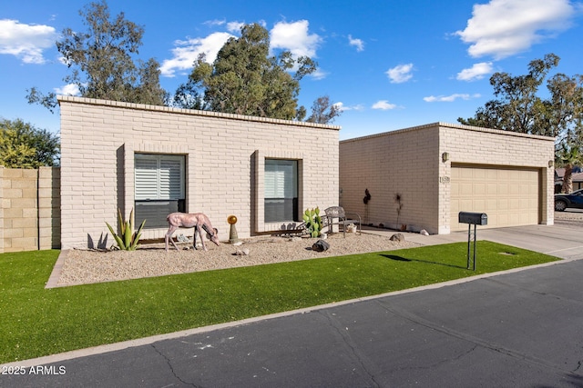 view of front of property featuring brick siding, driveway, a front lawn, and an outdoor structure