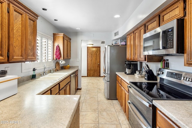 kitchen with a sink, appliances with stainless steel finishes, and brown cabinetry