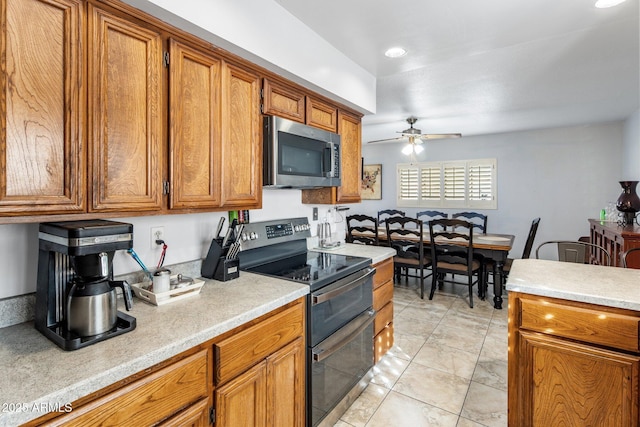 kitchen featuring brown cabinets, stainless steel appliances, light countertops, and ceiling fan