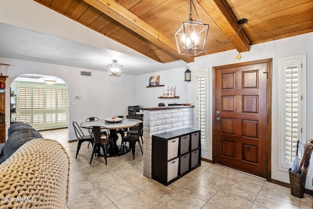 dining space featuring visible vents, baseboards, beamed ceiling, wood ceiling, and arched walkways