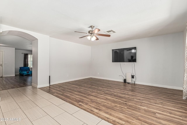 8939 W Villa Rita Dr, Peoria, AZ 85382 - unfurnished living room with arched walkways, ceiling fan, and wood finished floors