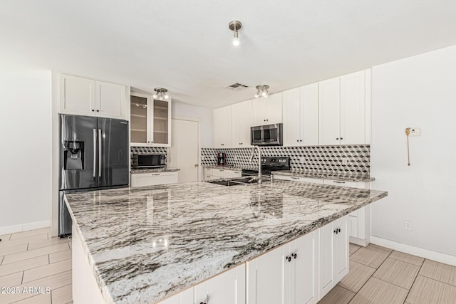 8939 W Villa Rita Dr, Peoria, AZ 85382 - kitchen featuring stainless steel appliances, backsplash, white cabinets, glass insert cabinets, and light stone counters