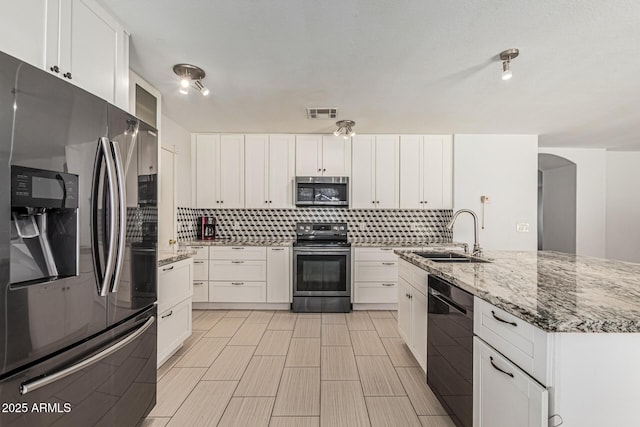 8939 W Villa Rita Dr, Peoria, AZ 85382 - kitchen with appliances with stainless steel finishes, backsplash, white cabinets, and light stone countertops