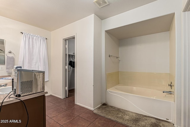 8939 W Villa Rita Dr, Peoria, AZ 85382 - bathroom with tile patterned floors, a bath, vanity, and a walk in closet