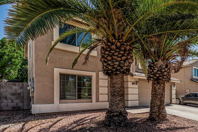 8939 W Villa Rita Dr, Peoria, AZ 85382 - view of side of home featuring stucco siding, concrete driveway, and a garage