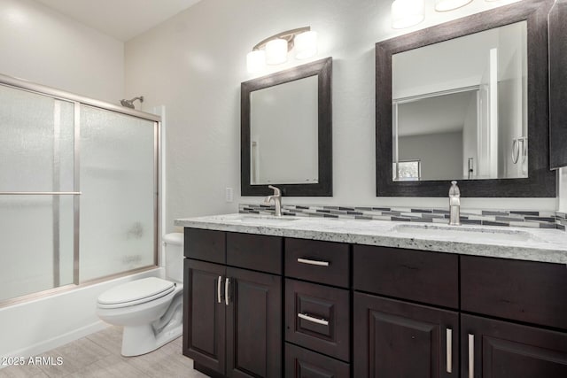 full bath with double vanity, backsplash, combined bath / shower with glass door, and a sink