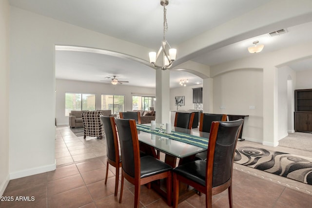 dining area with arched walkways, ceiling fan, visible vents, baseboards, and tile patterned floors