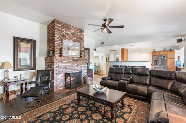 living room featuring ceiling fan, a fireplace, dark hardwood / wood-style flooring, and vaulted ceiling