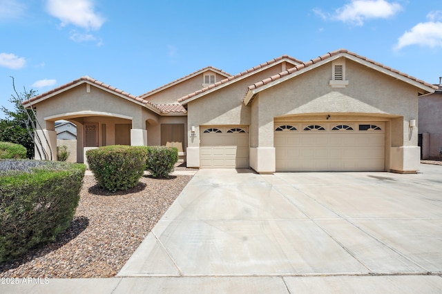 4414 W Monte Way, Laveen, AZ 85339 - mediterranean / spanish house with a garage, stucco siding, driveway, and a tiled roof