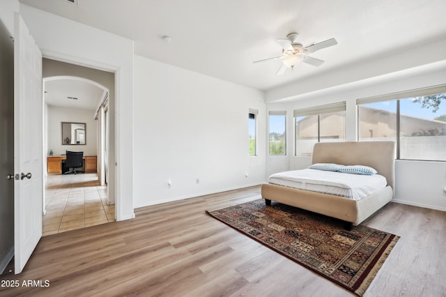 4414 W Monte Way, Laveen, AZ 85339 - bedroom featuring arched walkways, an office area, light wood-type flooring, baseboards, and ceiling fan