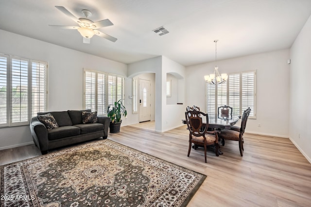 4414 W Monte Way, Laveen, AZ 85339 - living room with arched walkways, light wood-style flooring, a chandelier, and baseboards