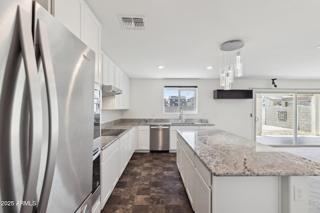 12531 W Glenn Dr, Glendale, AZ 85307 - kitchen featuring appliances with stainless steel finishes, a sink, stone finish floors, a kitchen island, and white cabinets