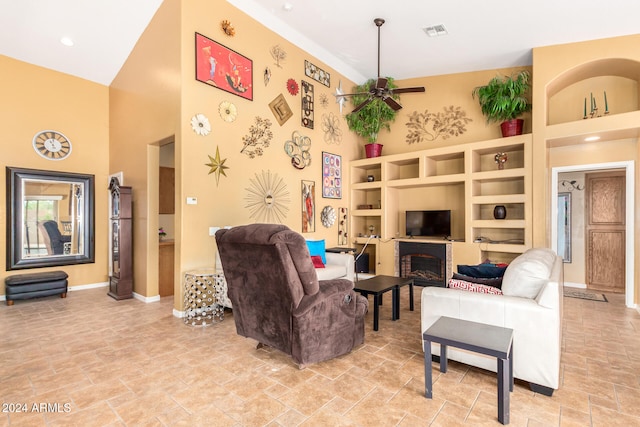 living room with built in features, a high ceiling, and ceiling fan