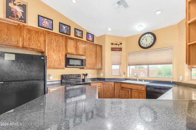 kitchen featuring black appliances, lofted ceiling, and sink