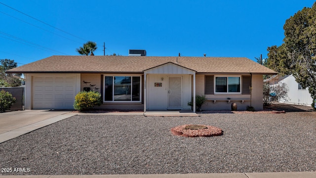 ranch-style home with concrete driveway, a shingled roof, an attached garage, and fence