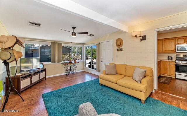 living area featuring dark wood-style flooring, visible vents, and lofted ceiling with beams