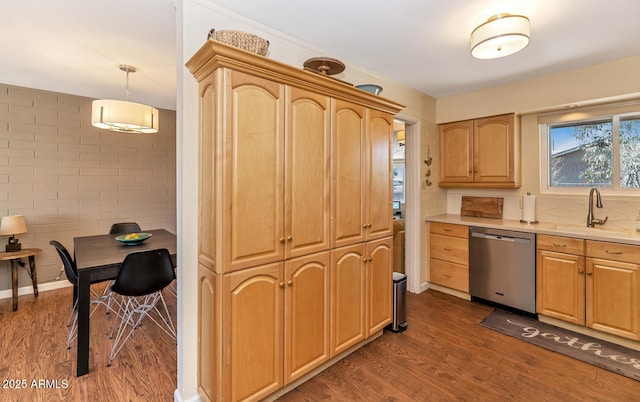 kitchen featuring light countertops, stainless steel dishwasher, dark wood-type flooring, and decorative light fixtures