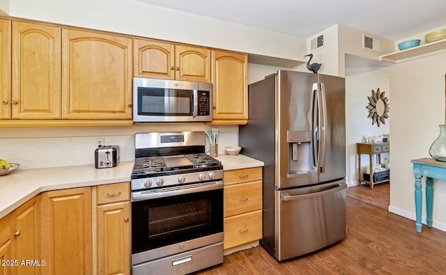 kitchen with dark wood-style flooring, light countertops, visible vents, decorative backsplash, and appliances with stainless steel finishes