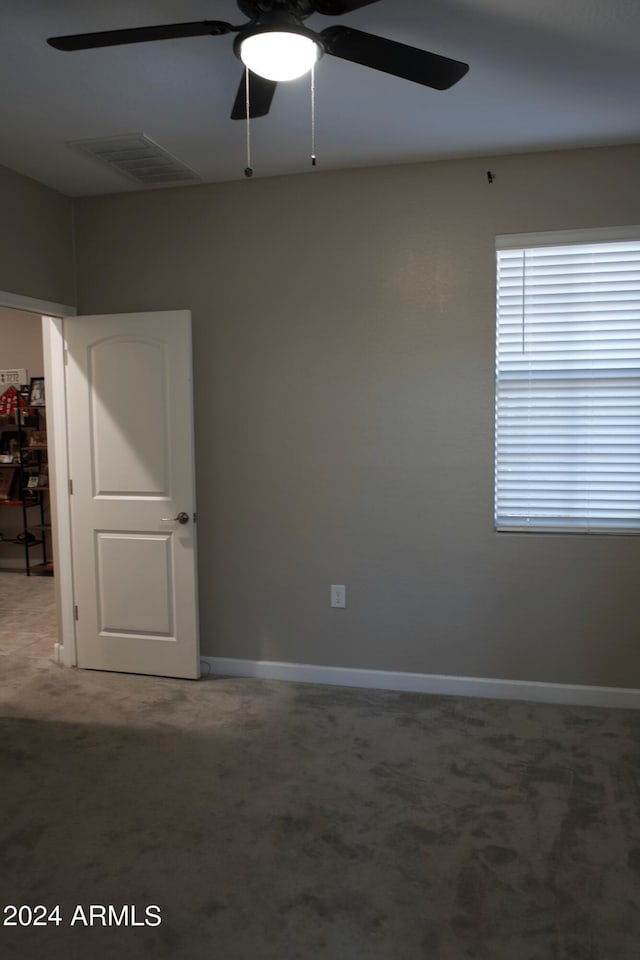 empty room with ceiling fan and carpet floors