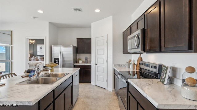 11890 E Cliffrose Ln, Florence, AZ 85132 - kitchen featuring stainless steel appliances, a sink, dark brown cabinets, a kitchen island with sink, and recessed lighting