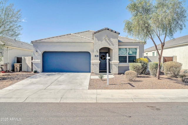 view of front of house with stucco siding, a tiled roof, concrete driveway, and a garage