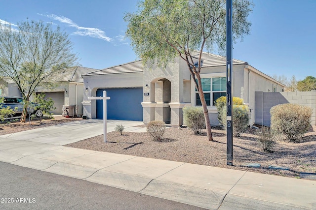 view of front of home with stucco siding, an attached garage, driveway, and a tile roof