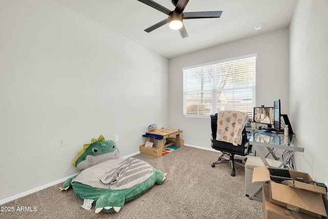 carpeted office with baseboards and a ceiling fan