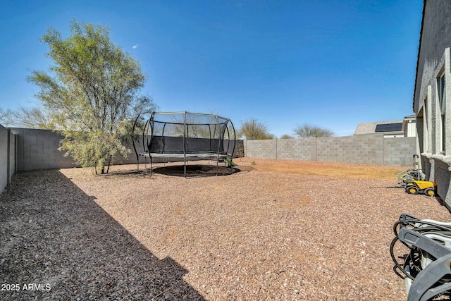 view of yard featuring a fenced backyard and a trampoline