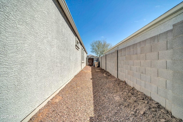 view of side of home featuring stucco siding and a fenced backyard