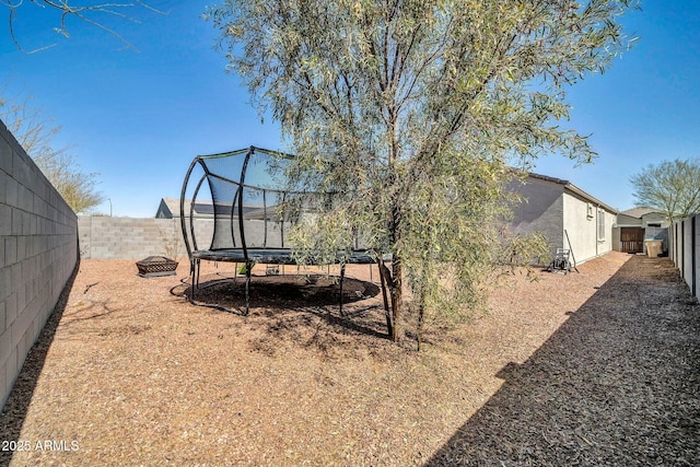 view of yard featuring a fenced backyard and a trampoline