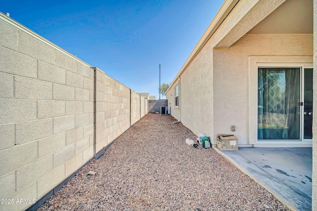 view of yard featuring central AC, a fenced backyard, and a patio area