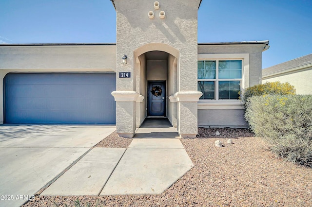 view of front facade with an attached garage, driveway, and stucco siding