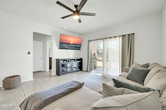 living room featuring tile patterned floors, a ceiling fan, baseboards, and vaulted ceiling