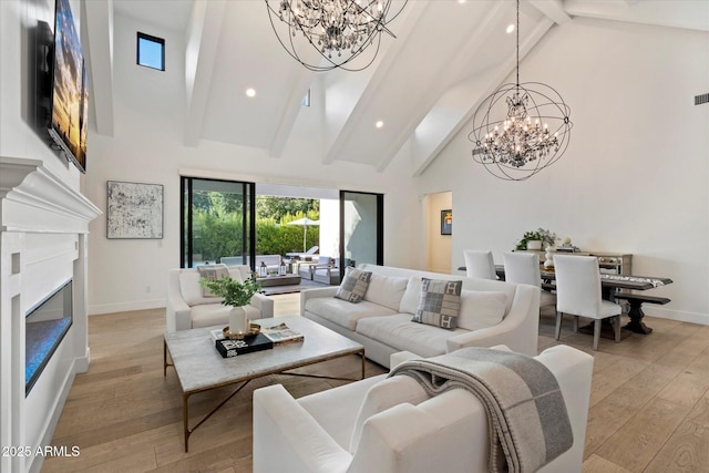 3808 E Fairmount Ave, Phoenix, AZ 85018 - living room featuring a chandelier, high vaulted ceiling, beam ceiling, light wood-style floors, and a glass covered fireplace